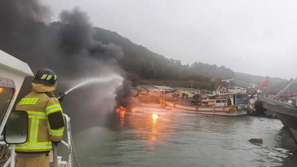해양 경찰이 어선의 화재를 진압하고 있다. 