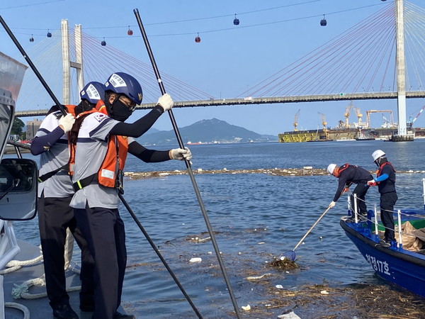 해양경찰과 해양환경관리공단직원들이 호우로 인해 유입된 해양쓰레기를 수거하고 있다.