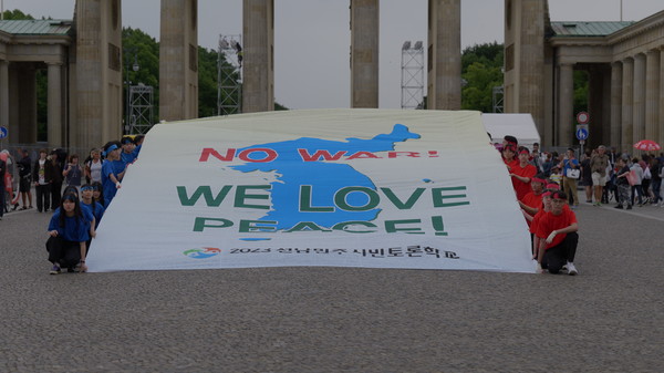 전남민주시민토론학교 캠프단이 브란덴부르크 문 앞 광장에서 ‘NO WAR! WE LOVE PEACE’란 현수막을 펼쳐 보이고 있다.